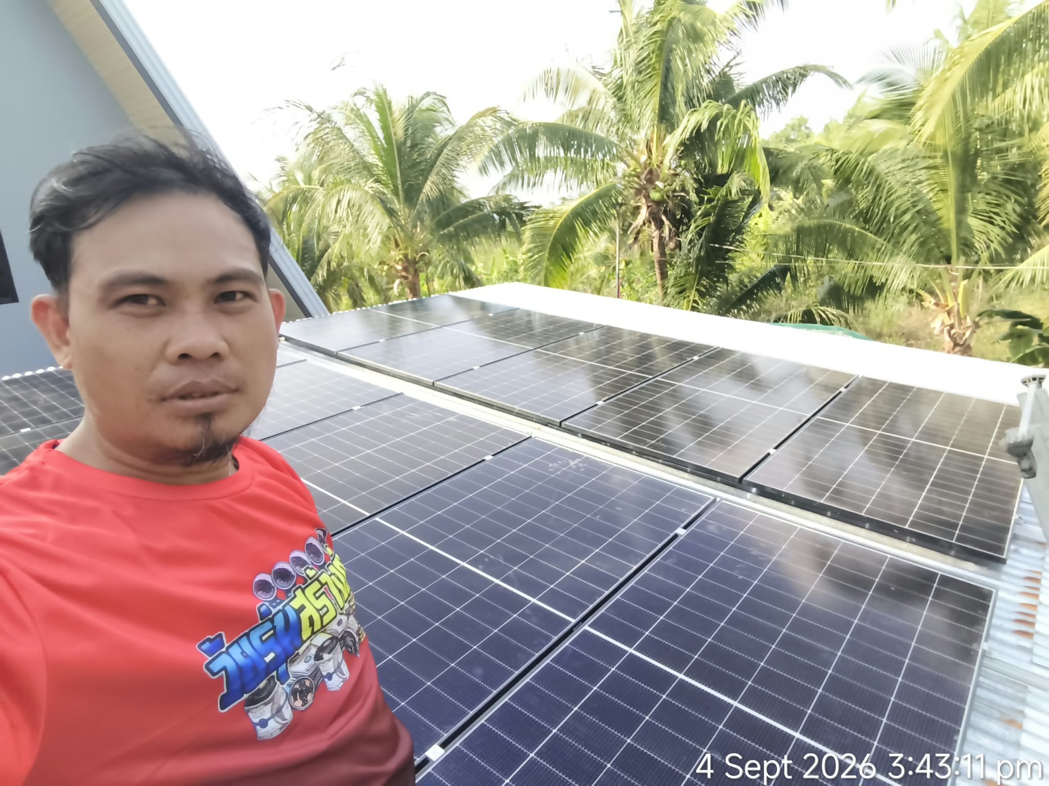 Installer taking a photo beside rooftop solar panels.