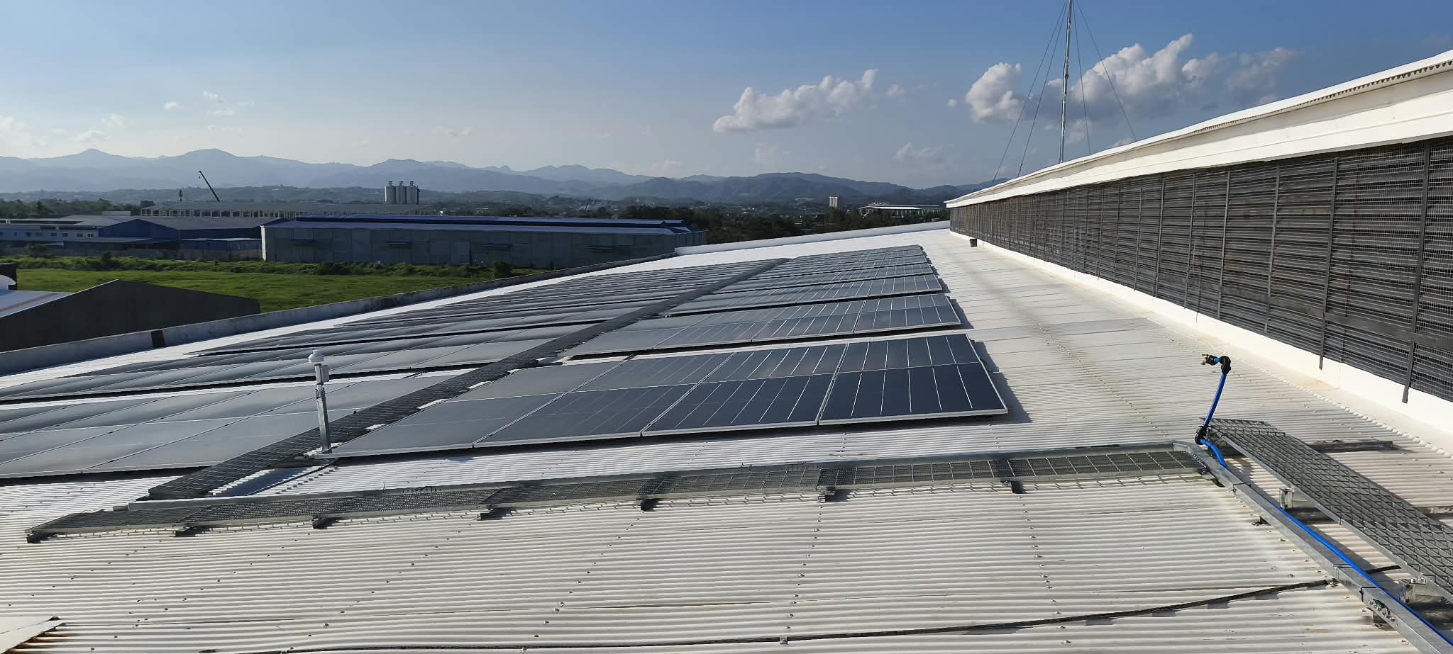 Solar panels beside a rooftop service path.